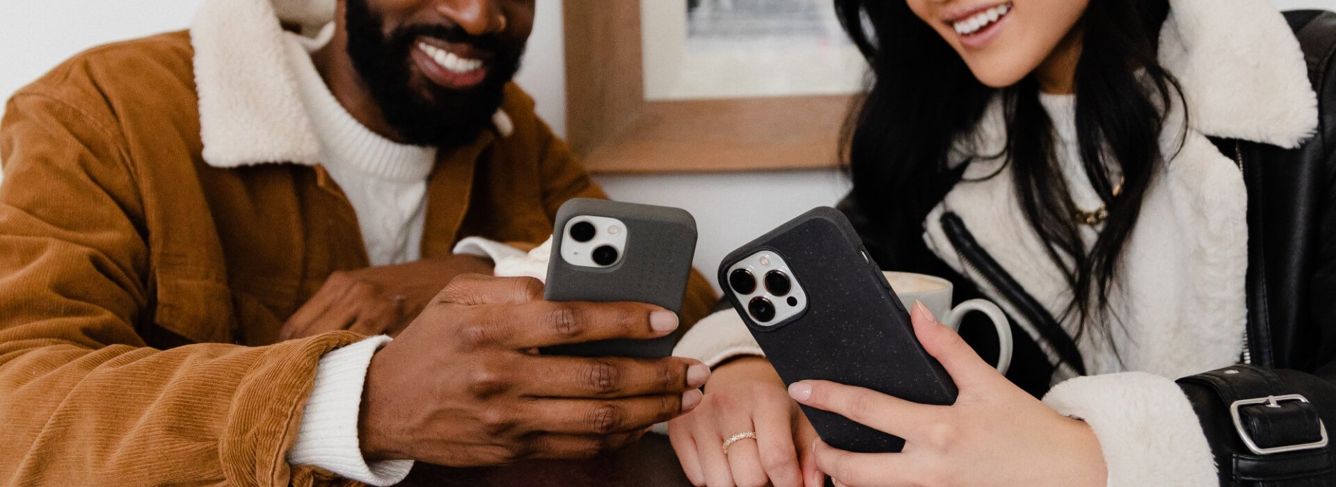 Two people at a cafe holding phones